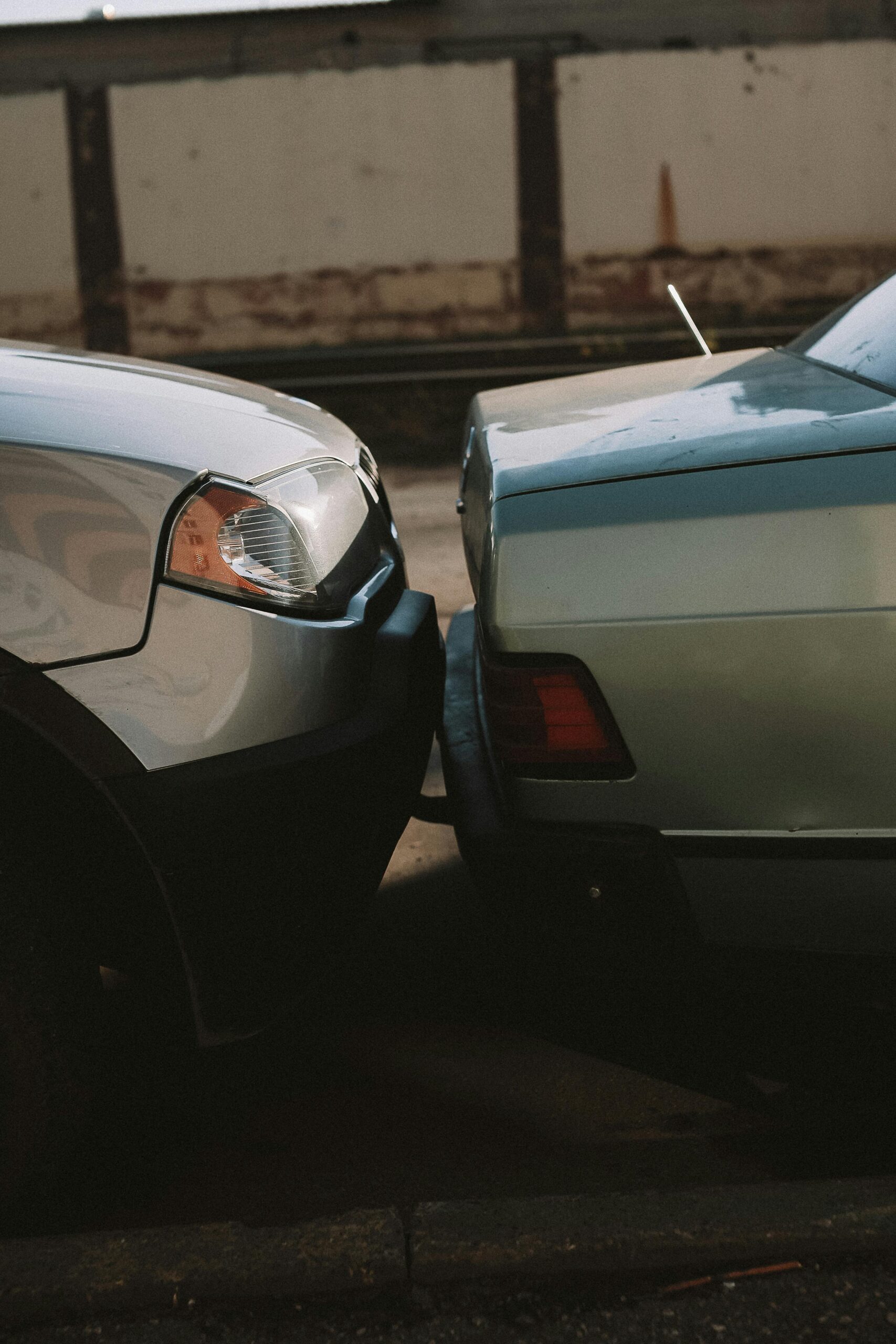 A close-up view showing the aftermath of a rear-end car collision in an outdoor setting.